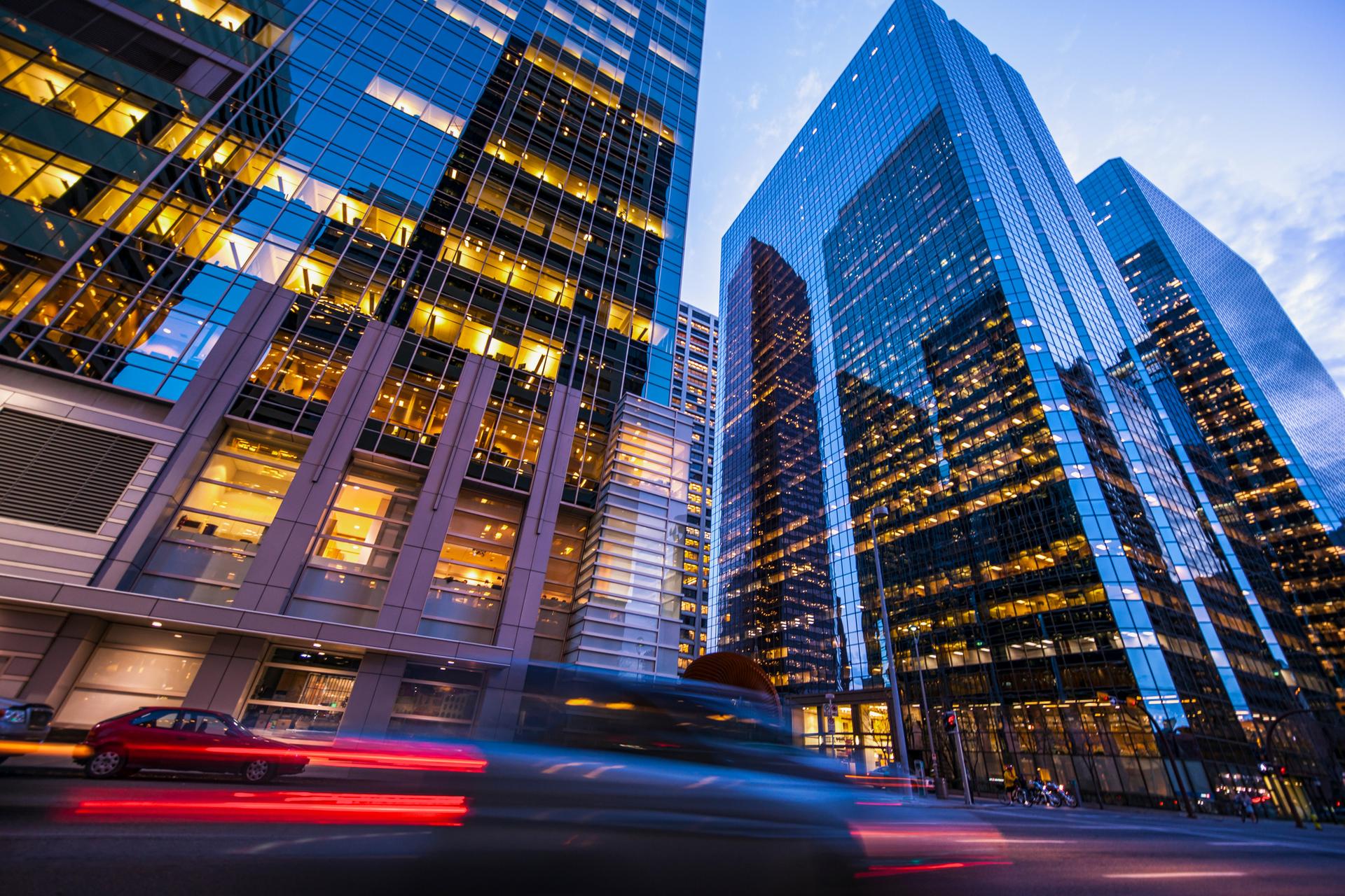 A timelapse of cars driving by tall city skyscrapers